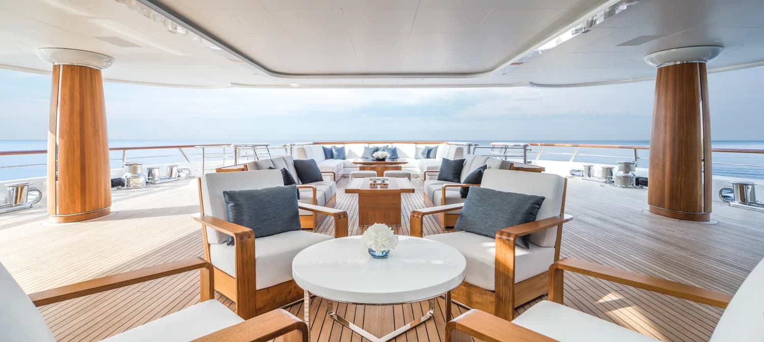 A beautifully set table on a superyacht, looking out to the ocean.